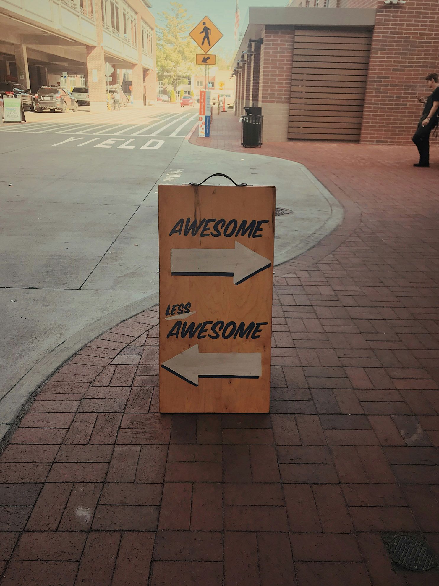 This picture features of a sign with two arrows pointing in different directions. The text on the sign reads Awesome and Less Awesome